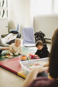 Bébés qui jouent et socialisent accompagnés de leurs parents dans un OCF