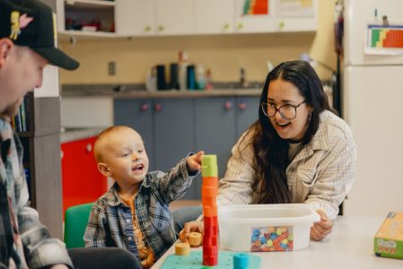 Une famille qui joue avec son enfant dans un organisme communautaire Famille (OCF)
