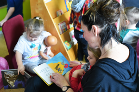 Dame qui fait la lecture à un enfant